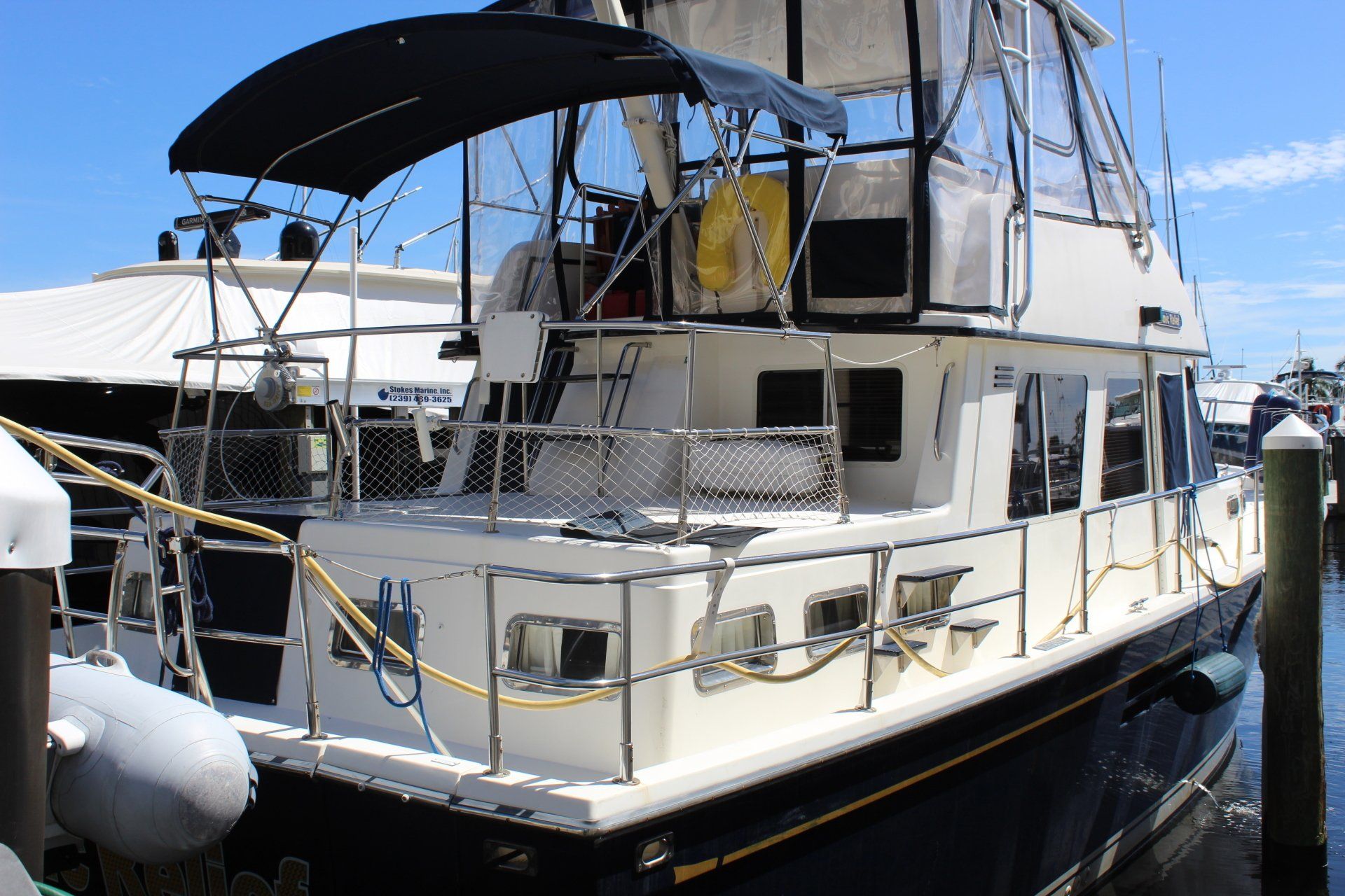A large white boat is docked at a marina.