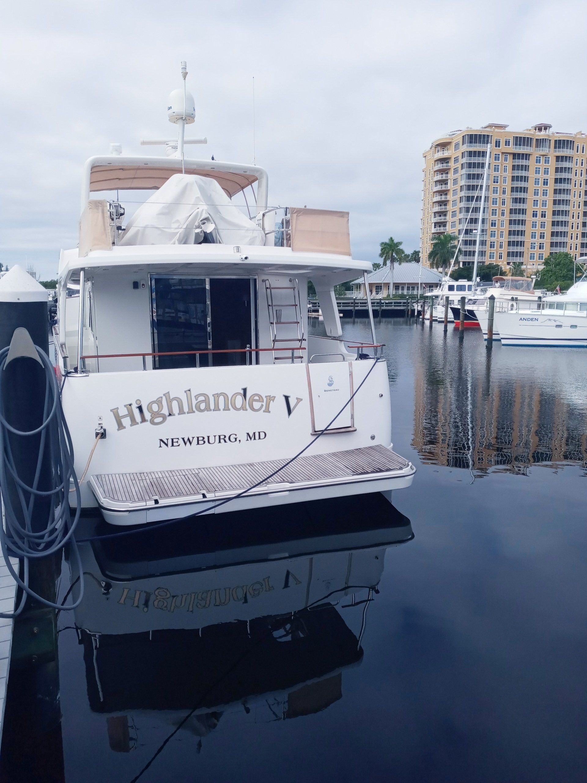 A boat named highlander is docked in a marina