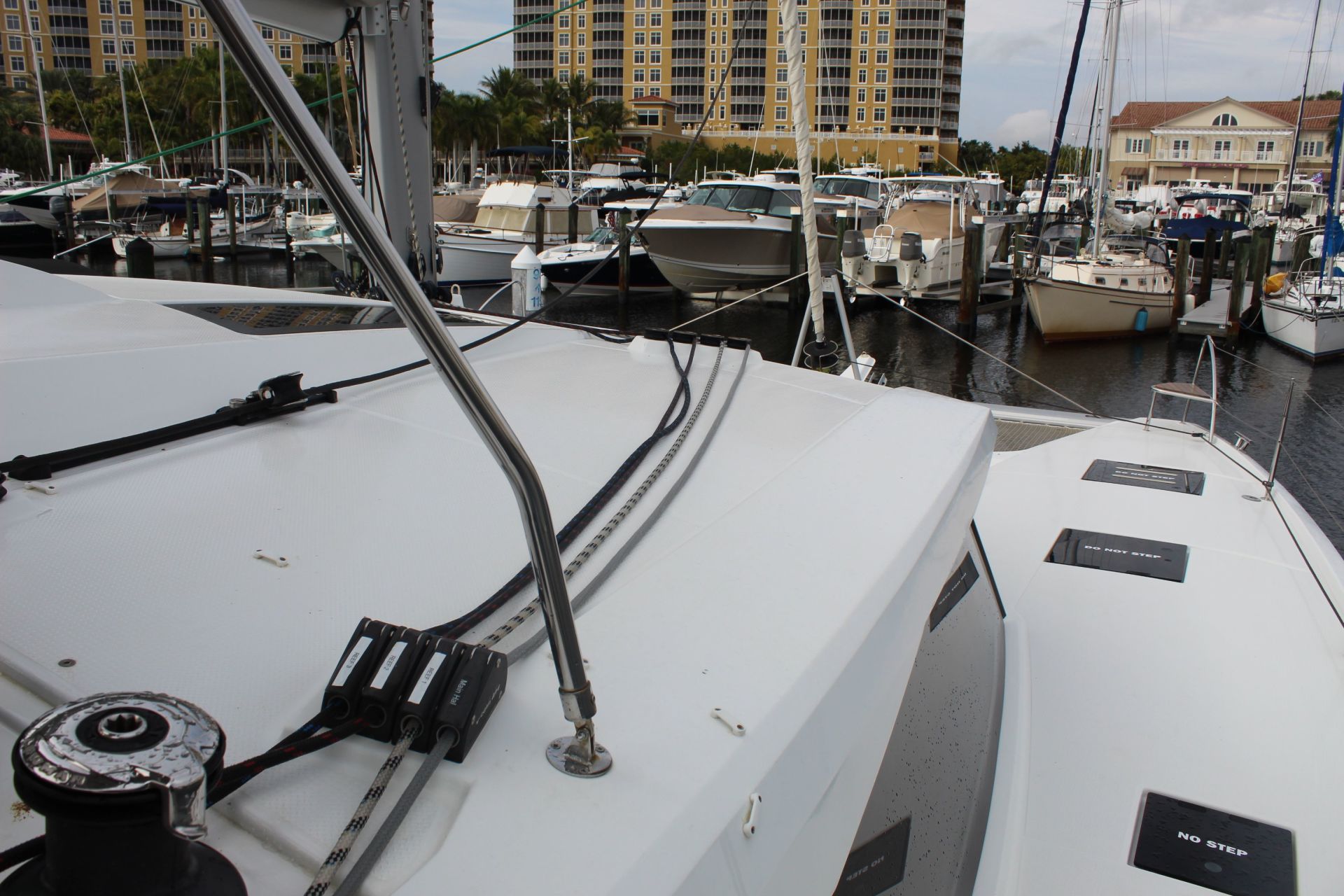 A white boat is docked in a marina with many other boats