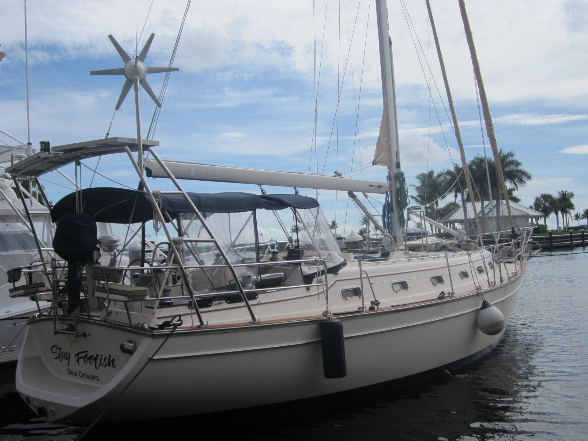 A sailboat is docked in the water and has the name ray reach on the back