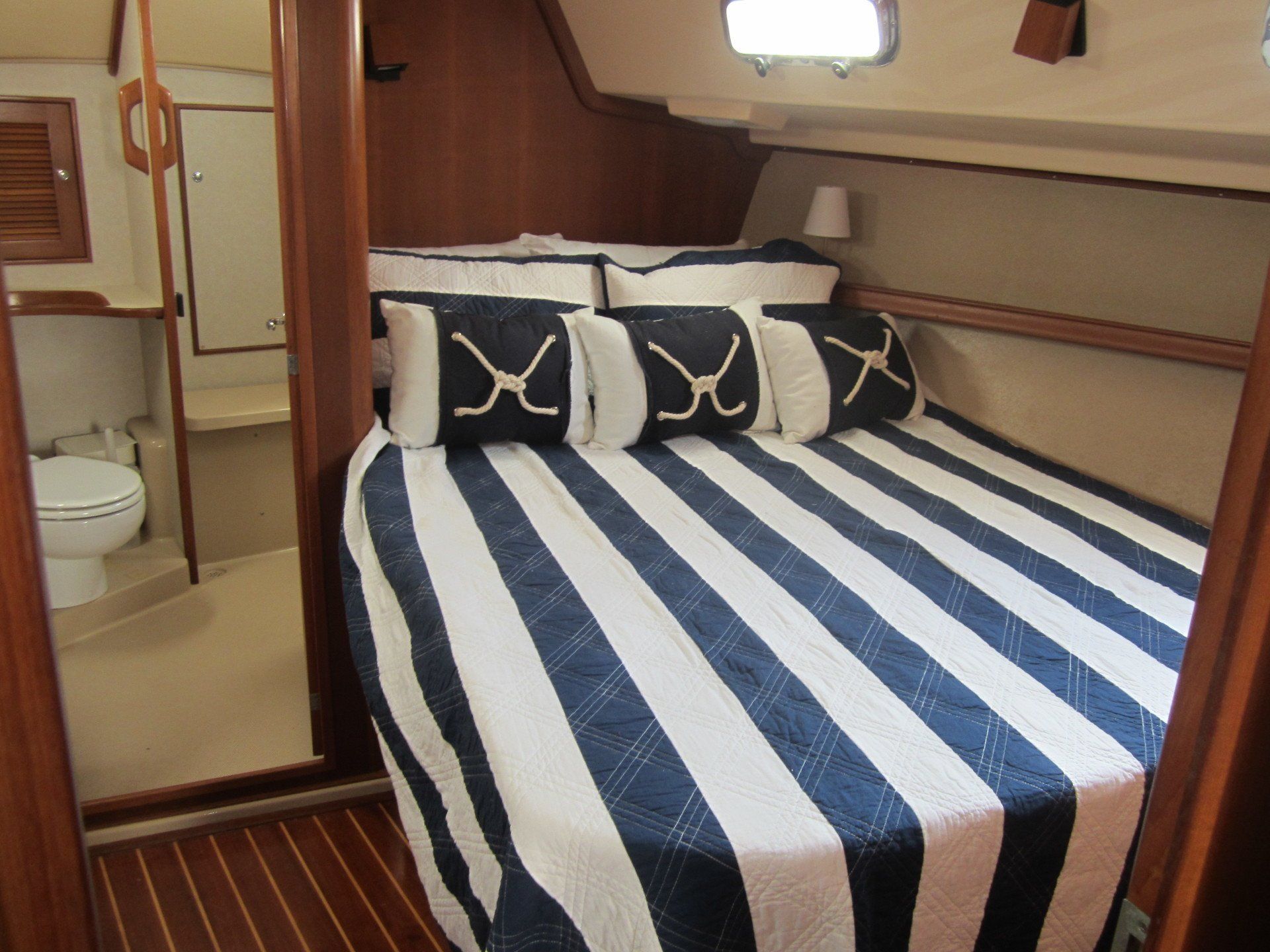 A blue and white striped bed with anchor pillows