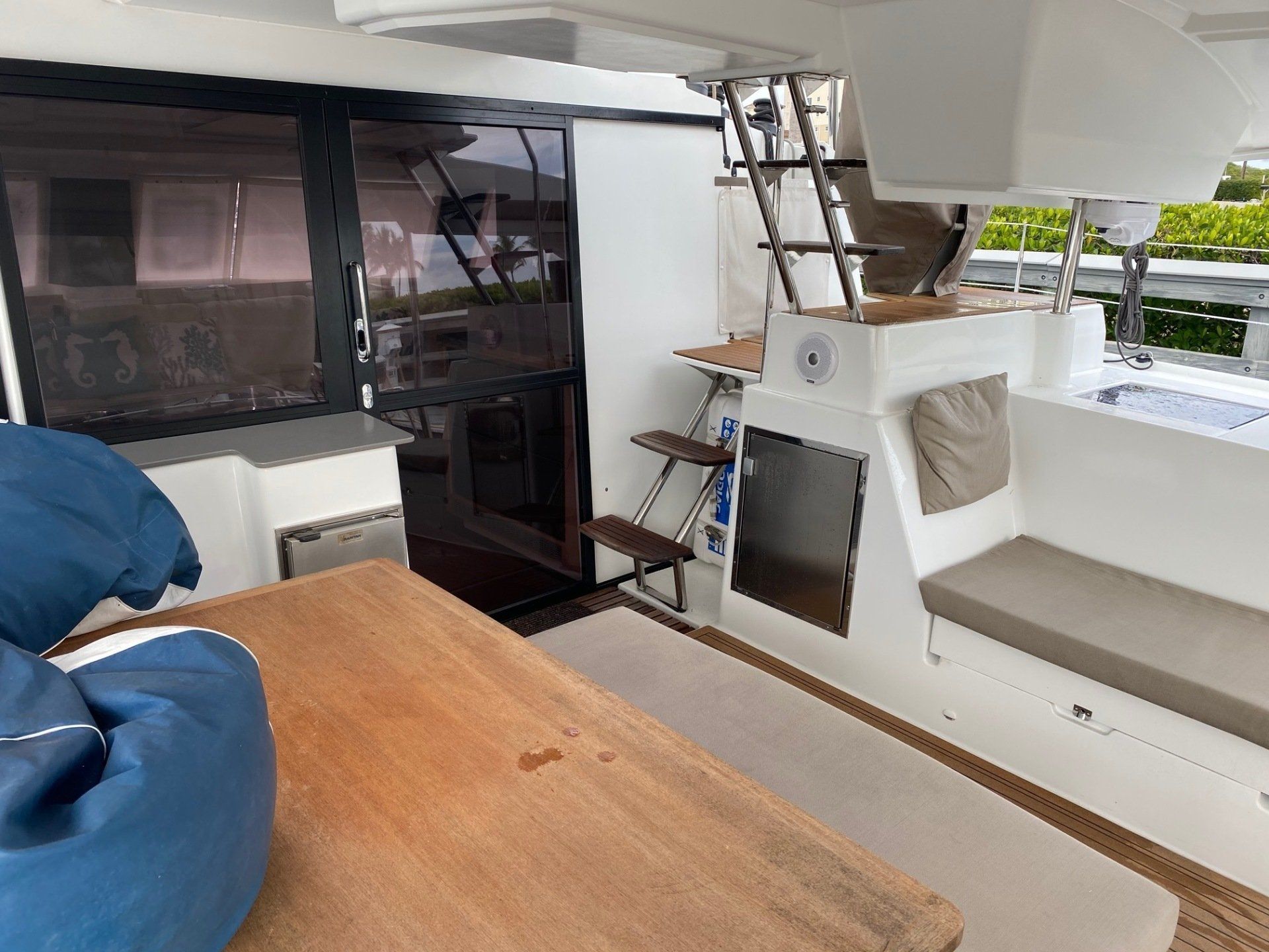The inside of a boat with a wooden table and stairs.