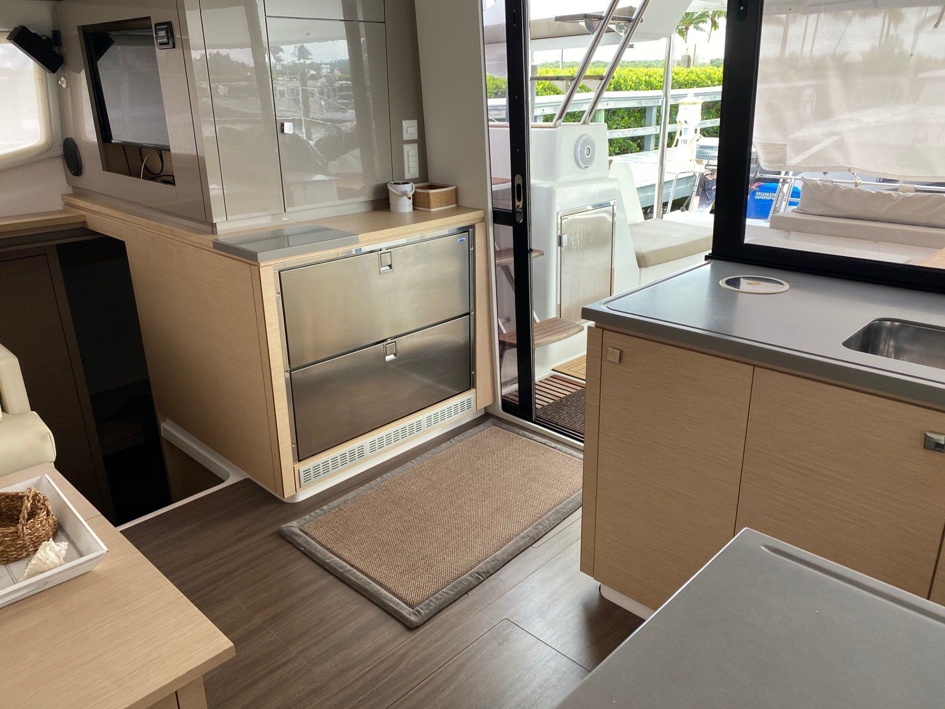 A kitchen with wooden cabinets and a sink in a boat.