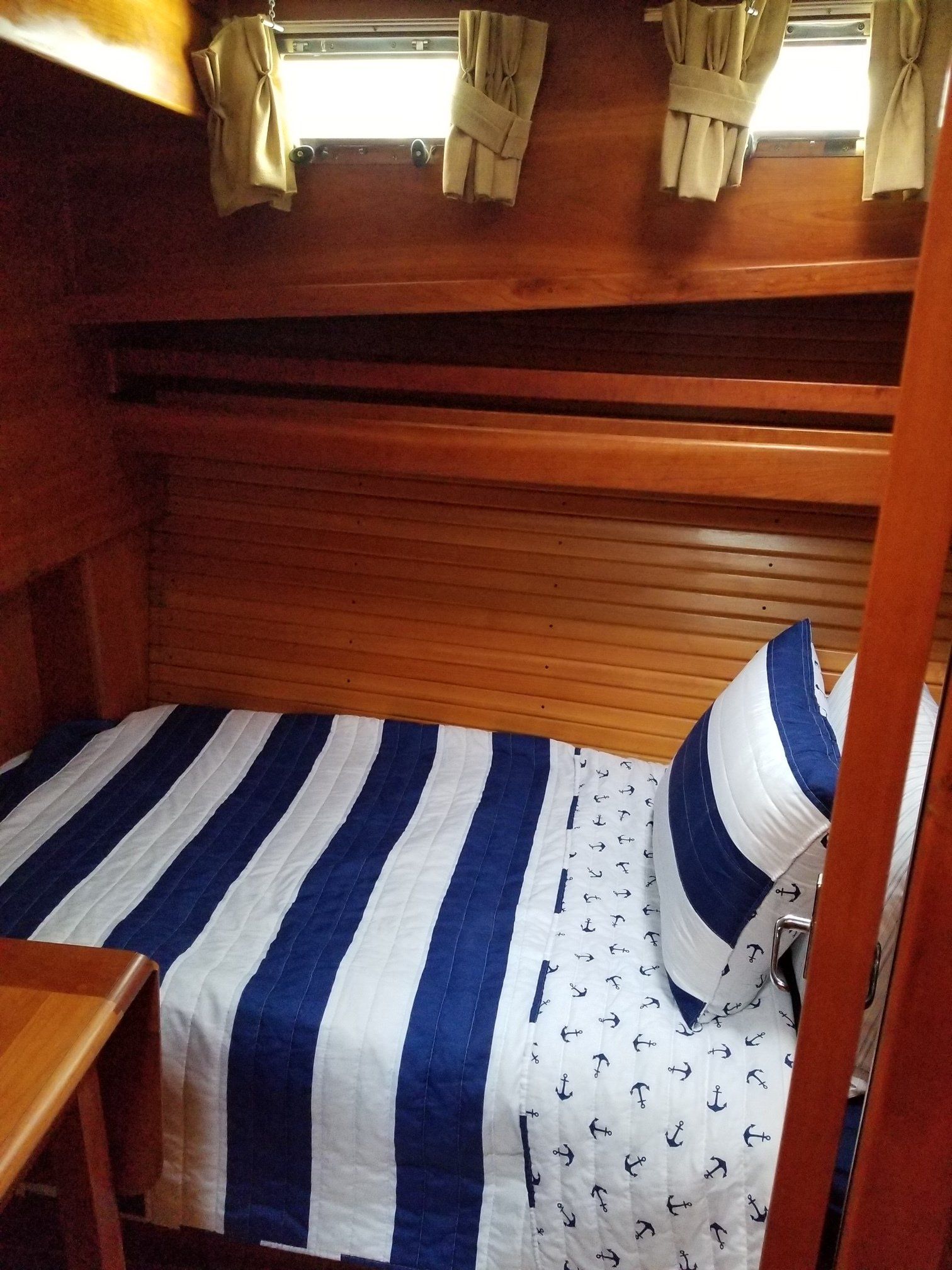 A bunk bed with a blue and white striped blanket