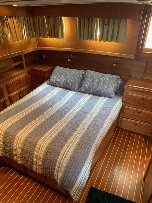 A bedroom on a boat with a bed and two nightstands