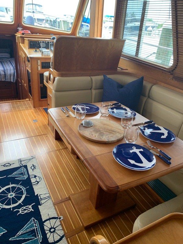 A wooden table with blue and white plates with an anchor on them