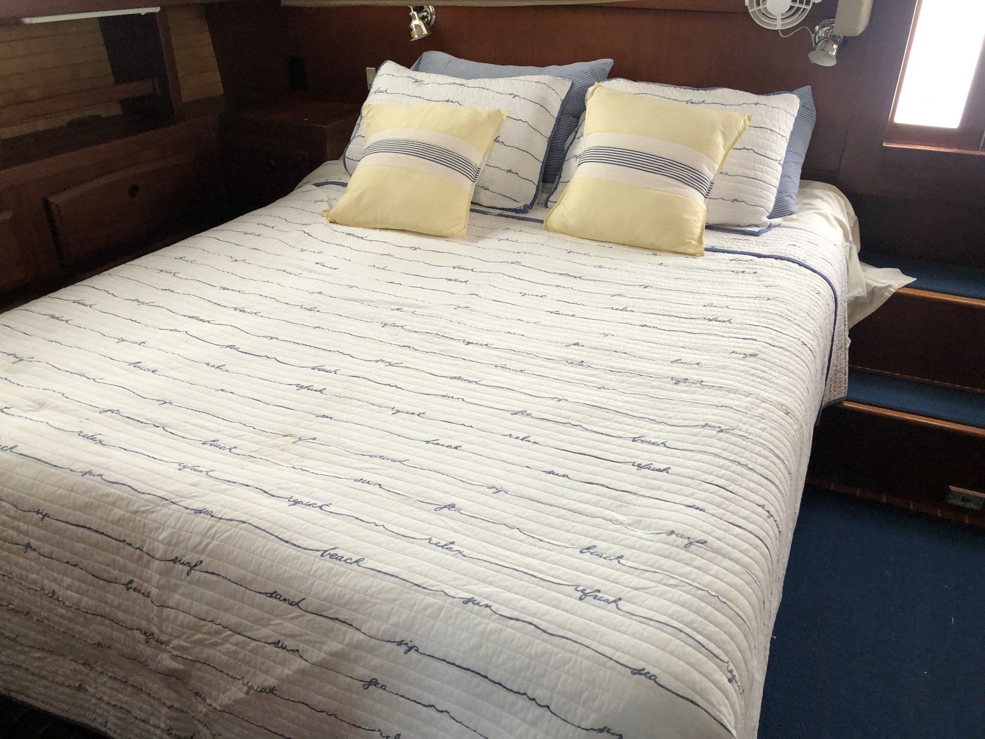 A bed with a striped blanket and pillows on it