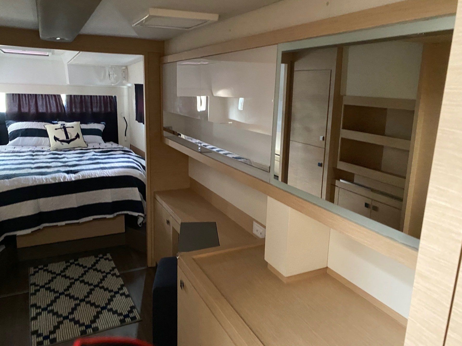 A bedroom on a boat with a bed and a desk.