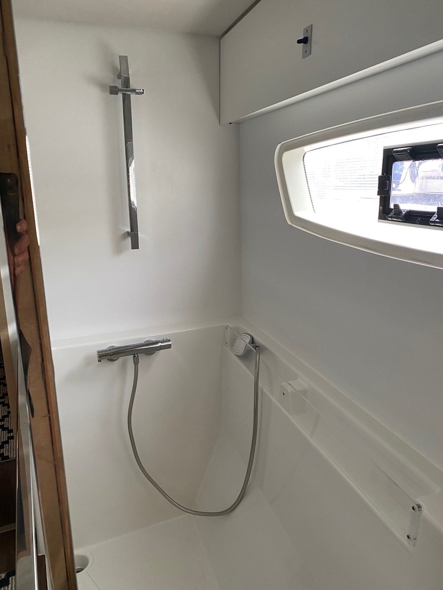A bathroom with a shower and a window.