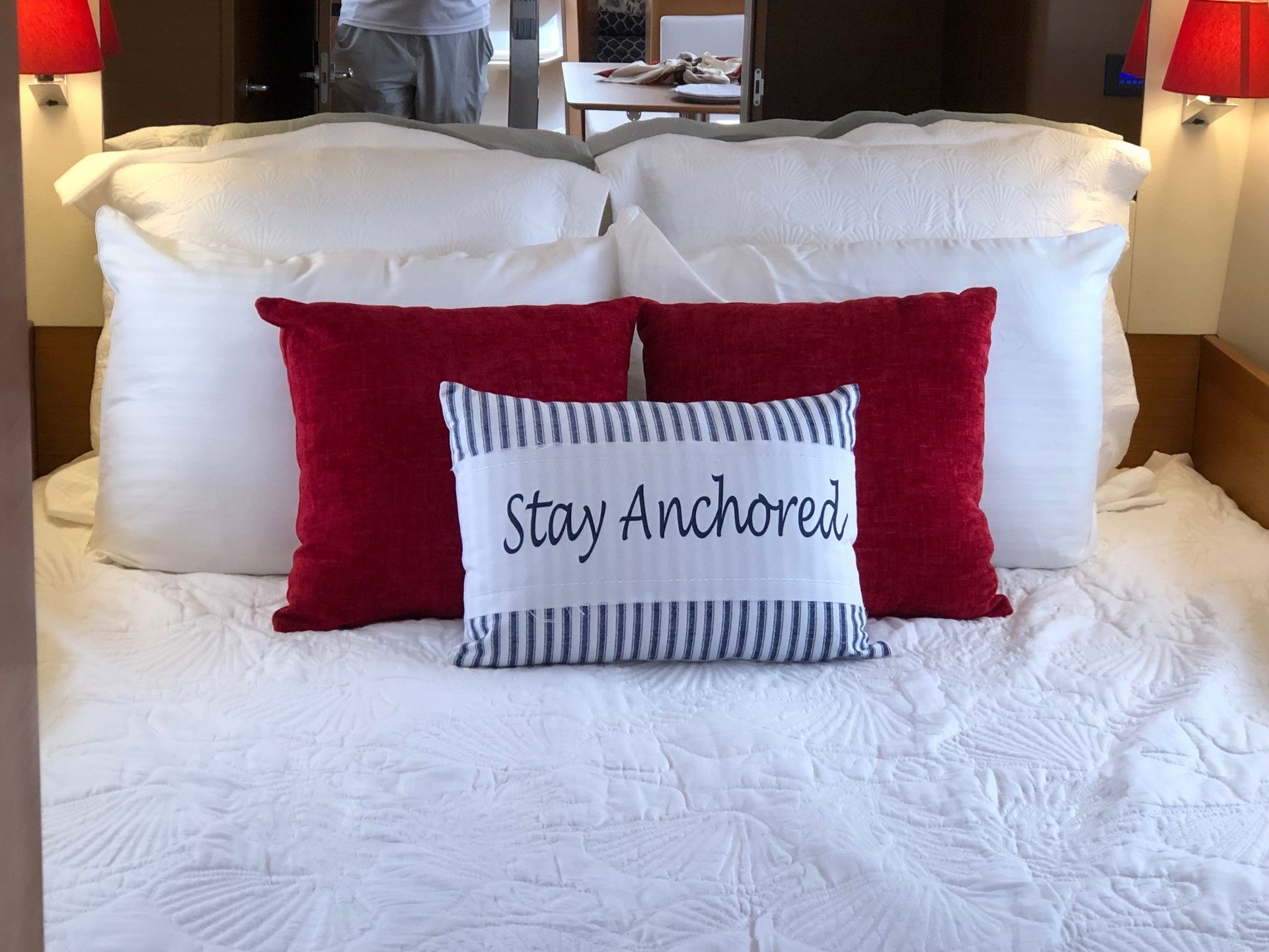 A bed with pillows and a pillow that says stay anchored