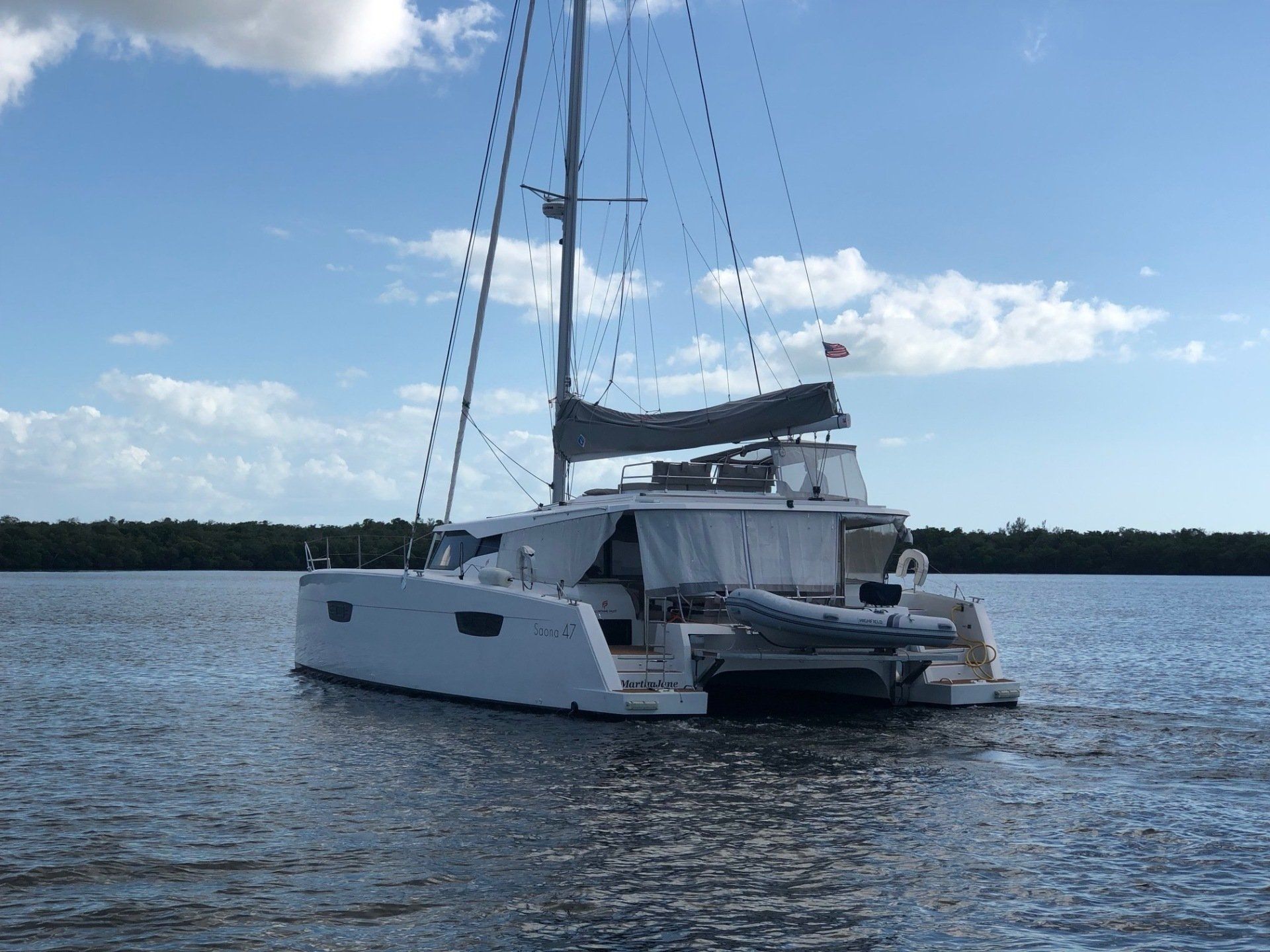 A white sailboat is floating on top of a body of water.
