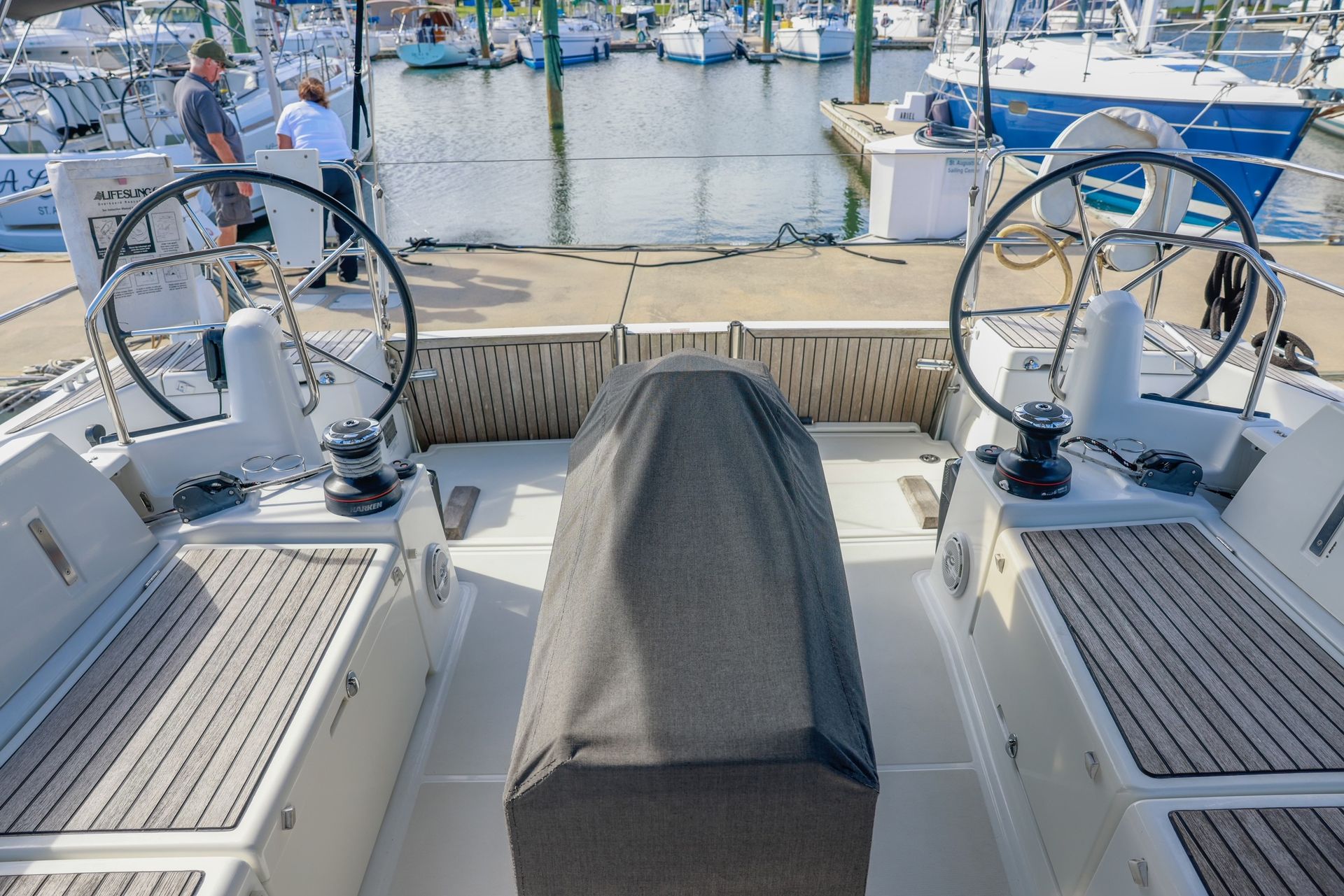 The steering wheel of a boat is covered with a black cover.