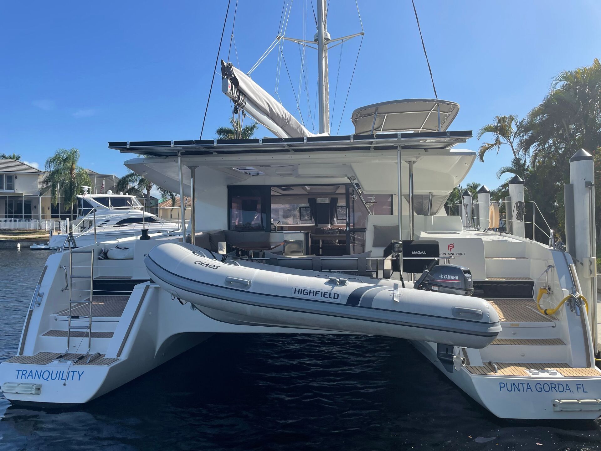 A boat with a raft attached to it is docked in the water.