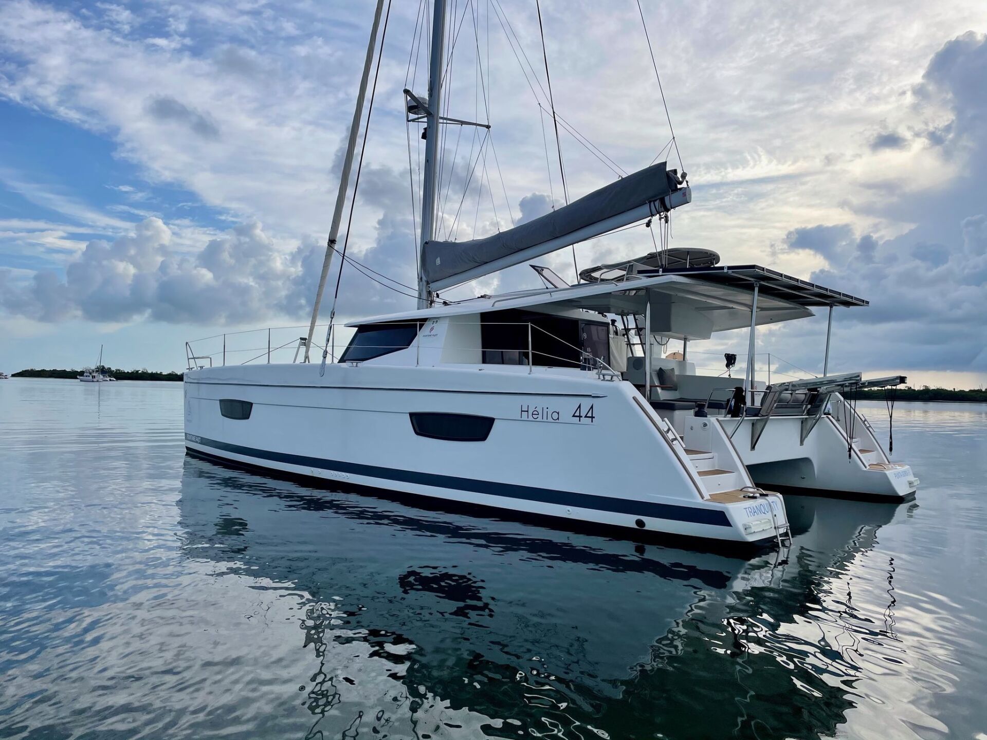 A white sailboat is floating on top of a body of water.