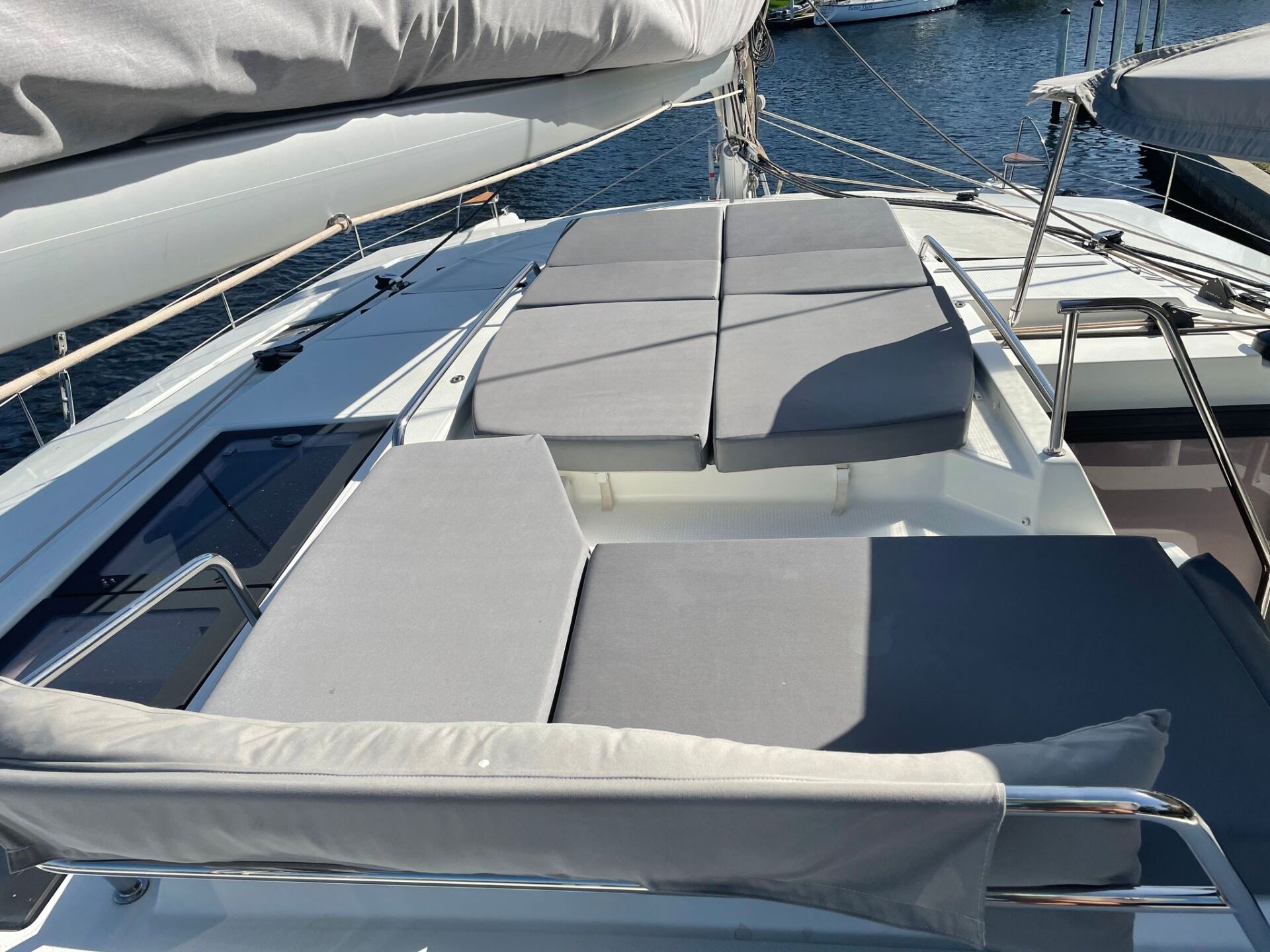 A boat with a lot of cushions on it is docked in the water.