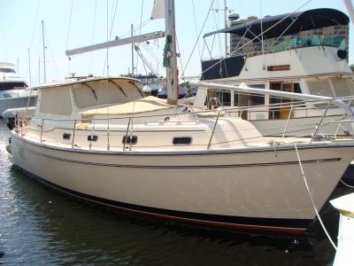 A sailboat is docked in a marina with other boats