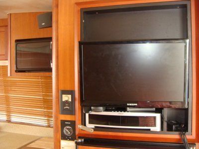 A flat screen tv is mounted in a wooden cabinet
