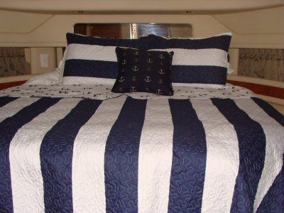 A bed with a blue and white striped comforter and pillows