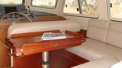 The inside of a boat with a table and a steering wheel