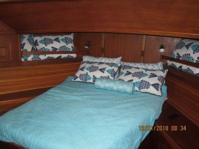 A bed with blue sheets and fish pillows on it