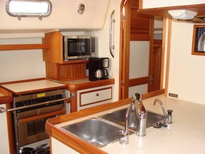 A kitchen with two sinks a microwave and a coffee maker