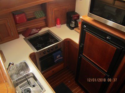 A kitchen with a stove a sink and a microwave