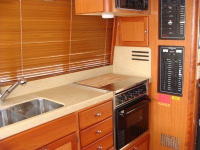 A kitchen with a sink stove and microwave on a boat