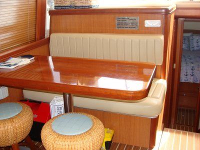 A wooden table with two wicker stools next to it