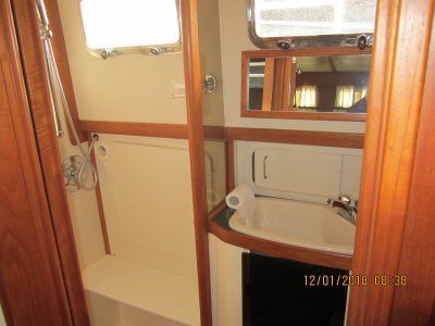 A bathroom on a boat with a sink and a shower.