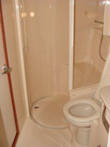 A bathroom with a toilet and a shower stall
