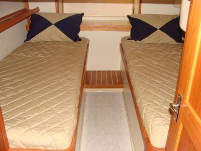 Two beds in a room with blue and tan pillows