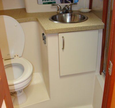 A bathroom with a toilet a sink and a first aid box