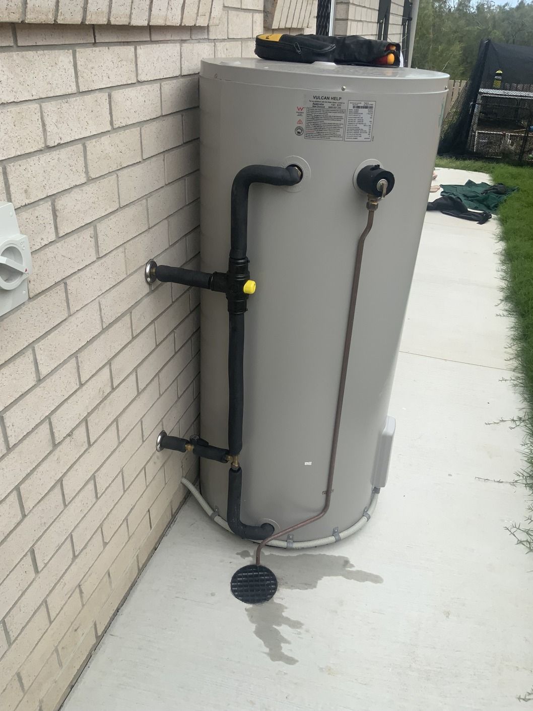 Man is Fixing a Water Heater With a Screwdriver — Bay City Plumbing in Urraween, QLD