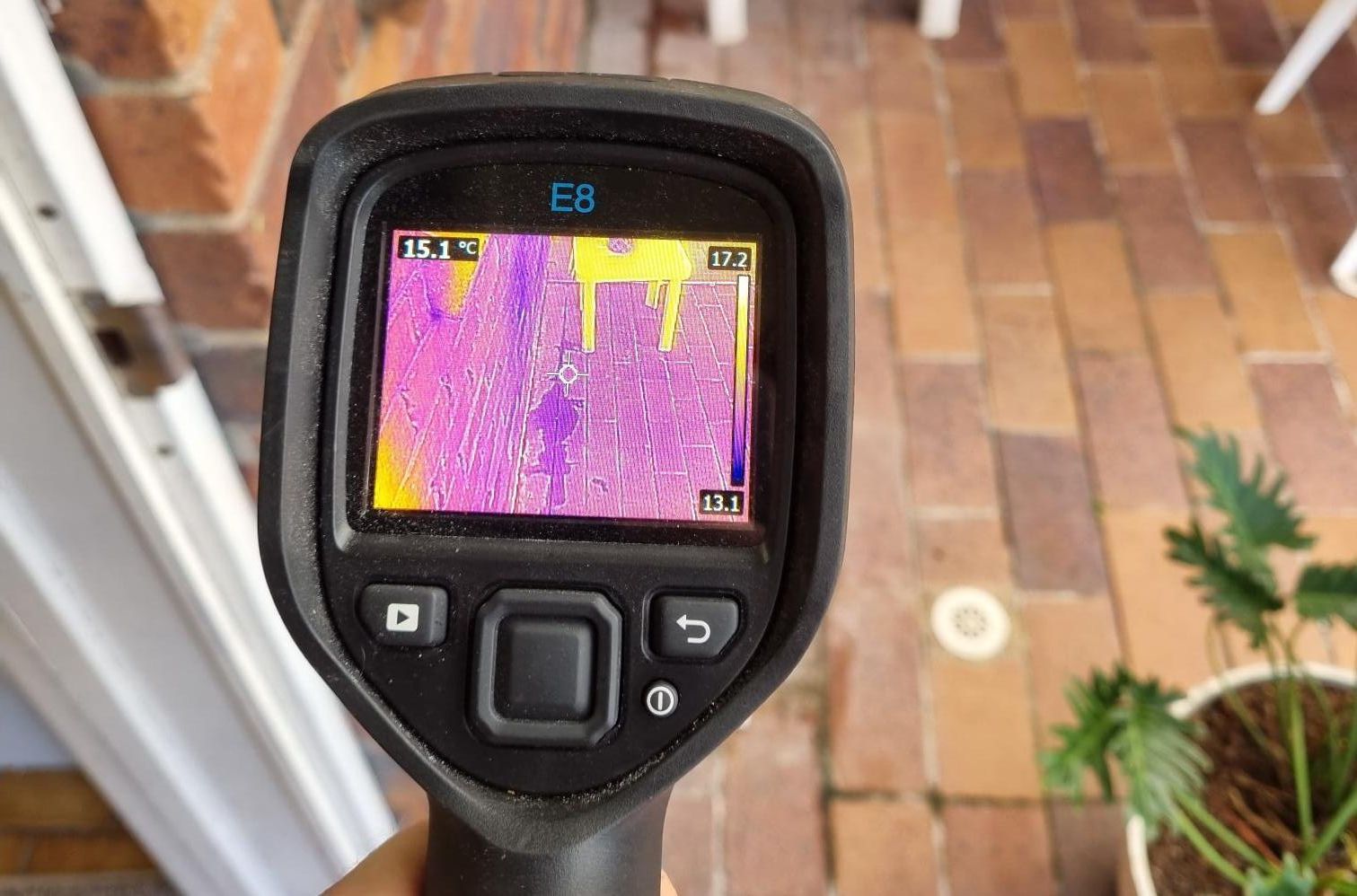 A Person Is Holding A Thermal Camera In Front Of A Potted Plant — Bay City Plumbing in Hervey Bay, QLD