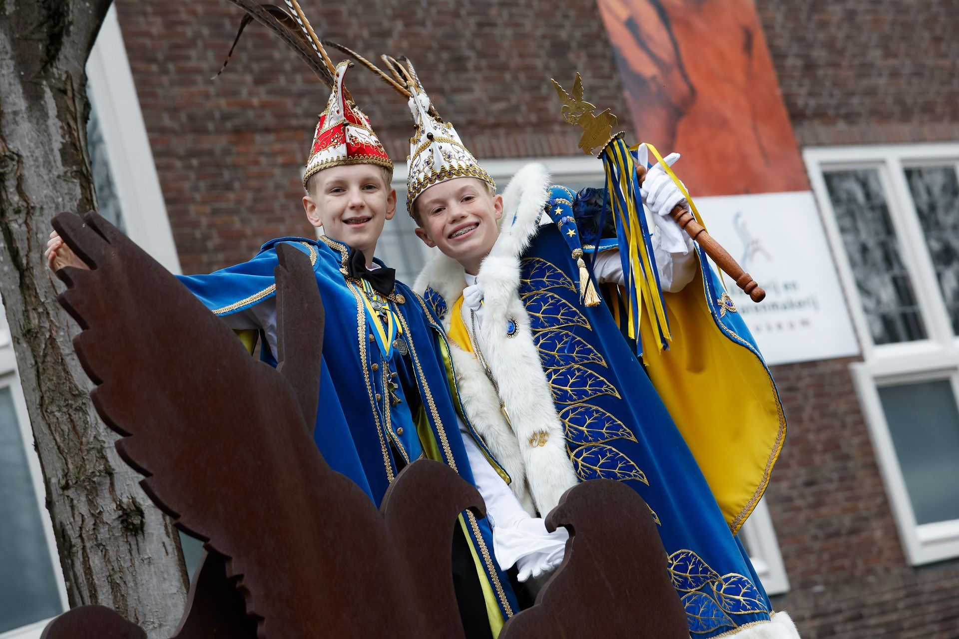 Een jonge jongen gekleed in een blauw en wit kostuum