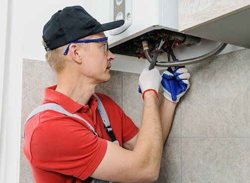 Plumbing Services — Man Fixing Broken Water Heater in Carrollton, TX Plumbing Services — Man Fixing Broken Water Heater in Carrollton, TX