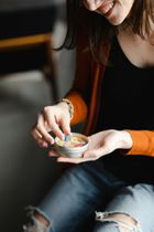 A woman is holding a small bowl of food in her hands.