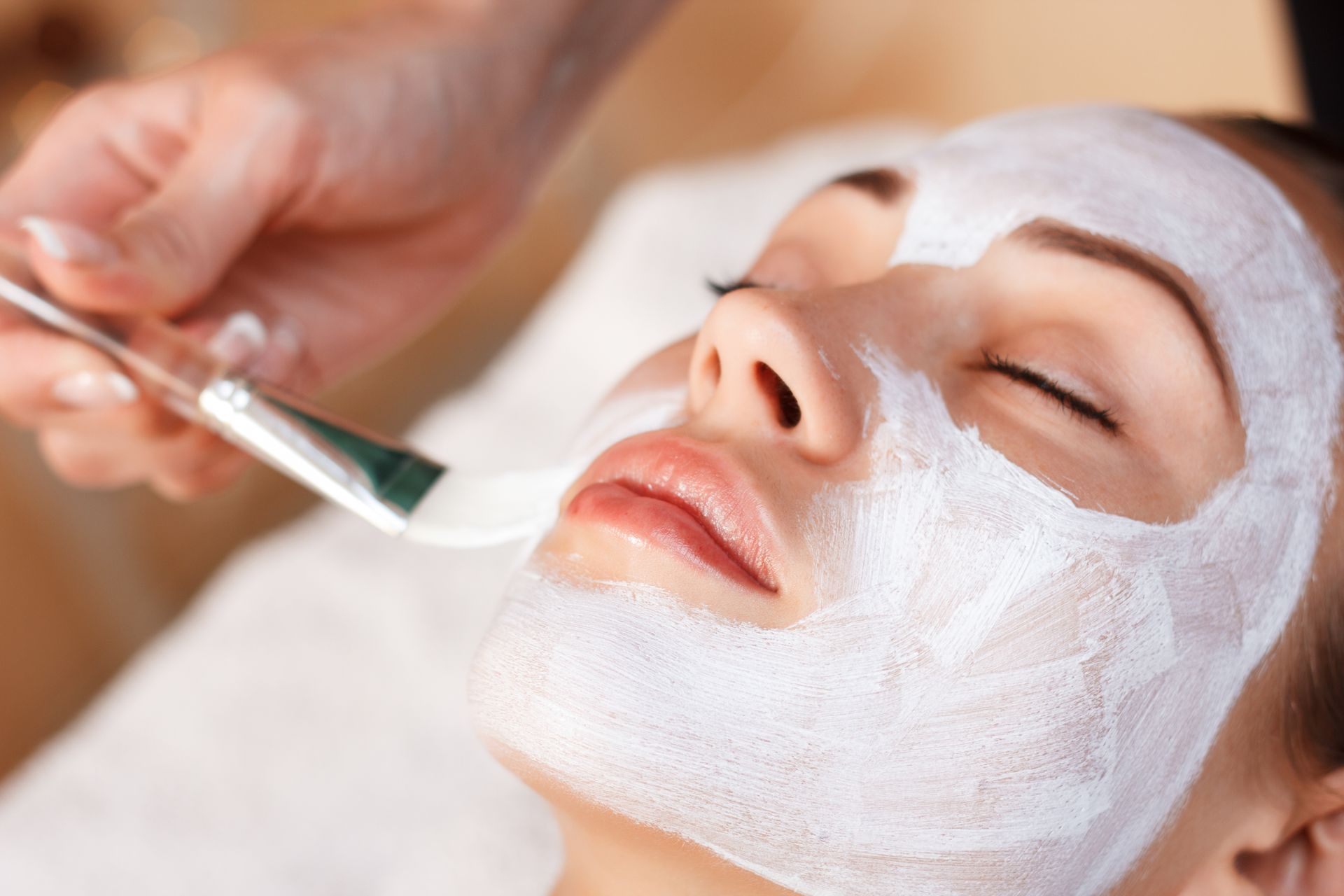 Just relax. Pleasant attractive woman closing her eyes and lying while having mask on her face.