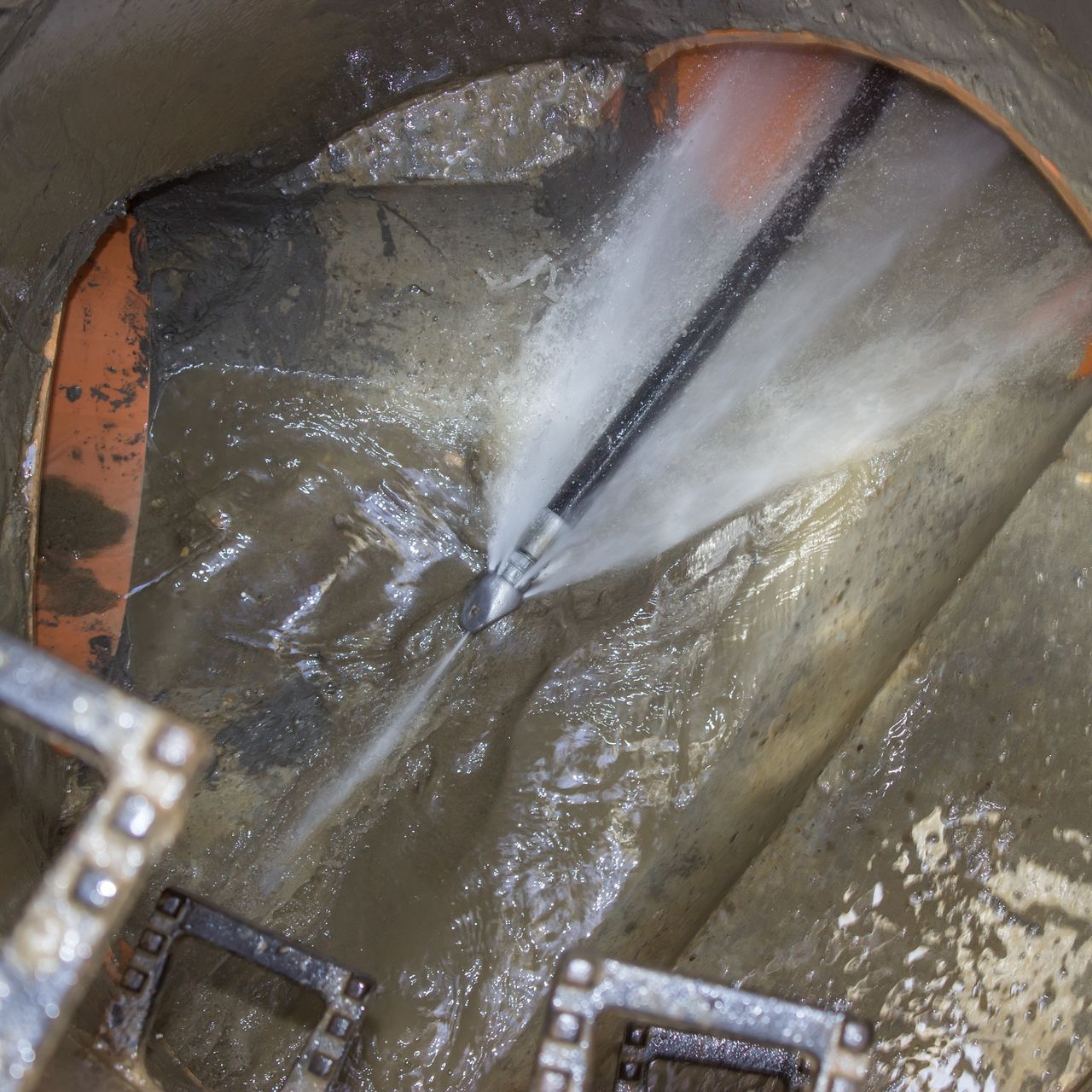 A hose is spraying water into a hole in the ground