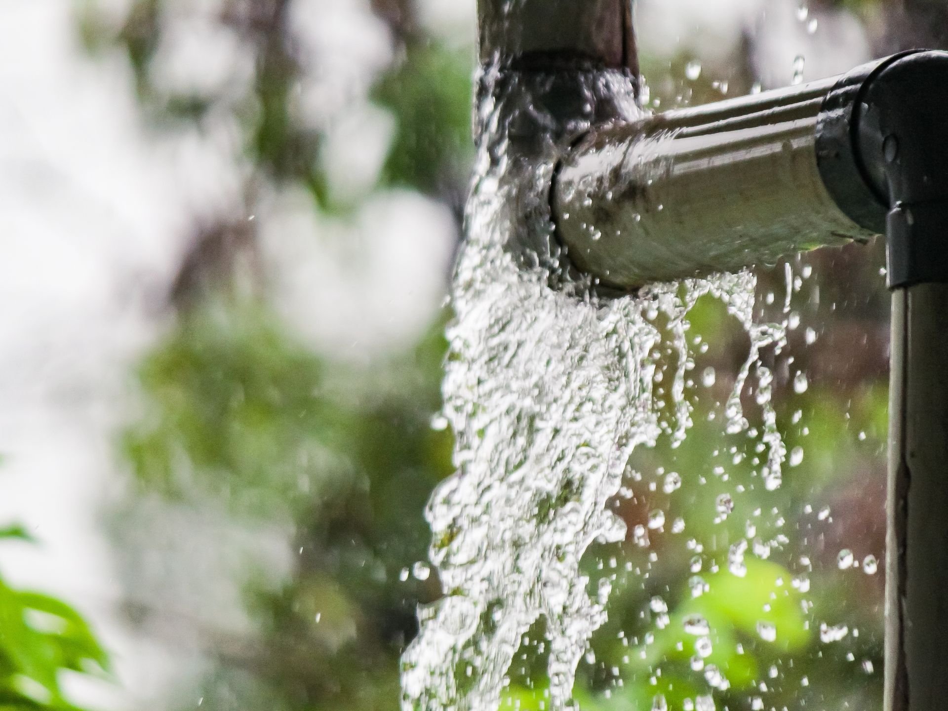 Water is coming out of a pipe in the rain.