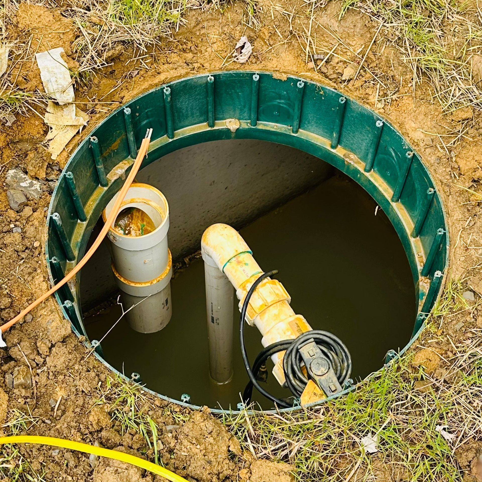 A septic tank is filled with water and has a hose coming out of it.