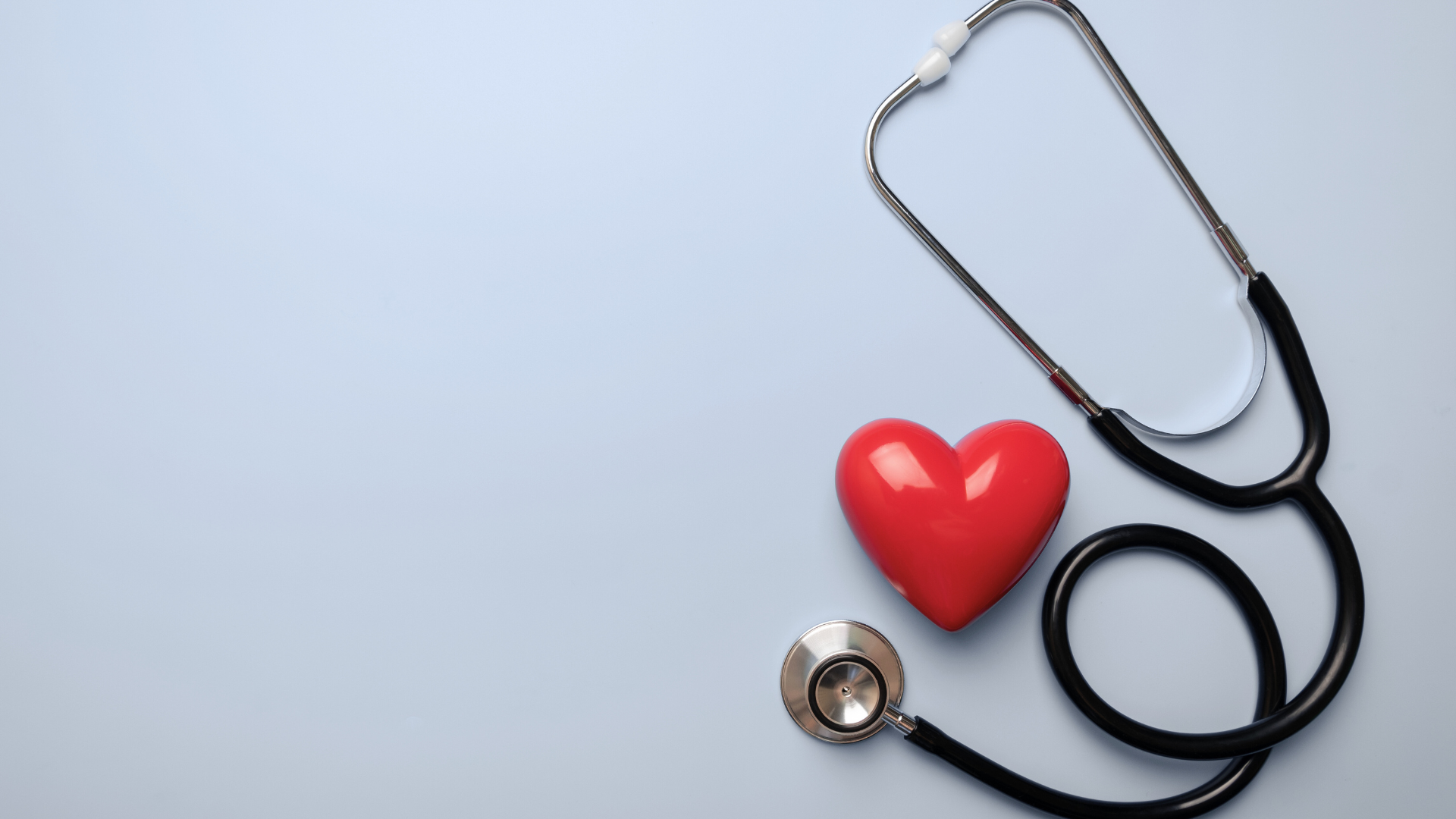 A red heart and a stethoscope on a blue background.