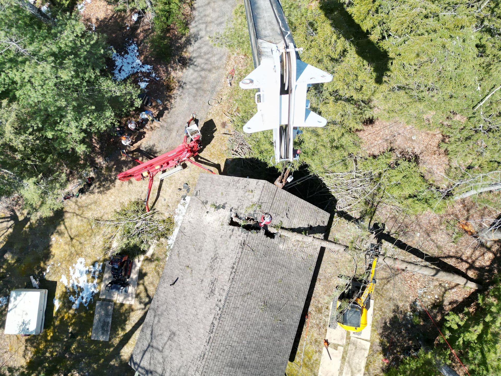 Overhead view of a building with a fighter jet on top; a crane is working in the yard.