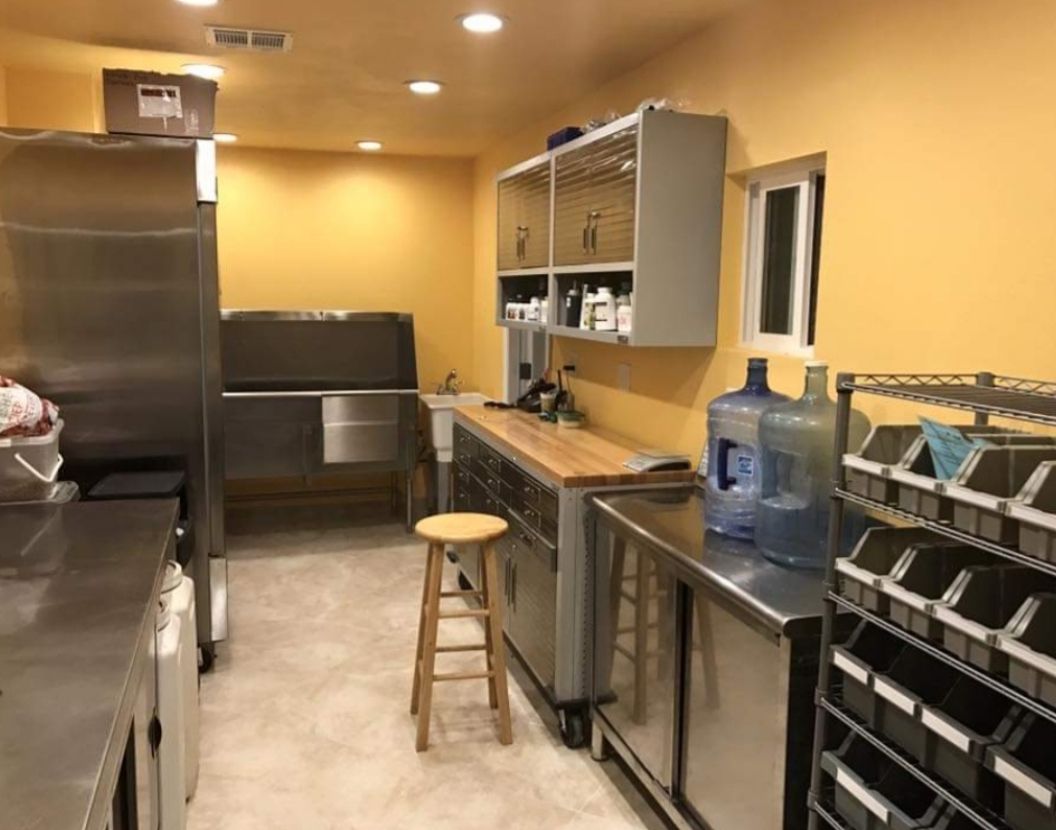 A kitchen with stainless steel appliances and a wooden stool