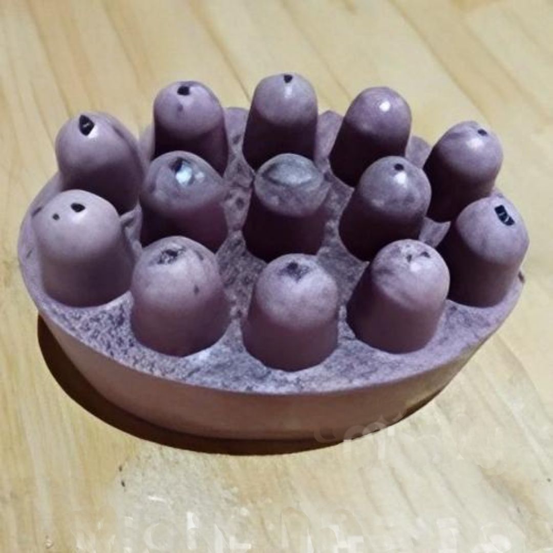 Jabón de masaje morado con 13 nódulos redondeados en la parte superior, colocado sobre una superficie de madera.
