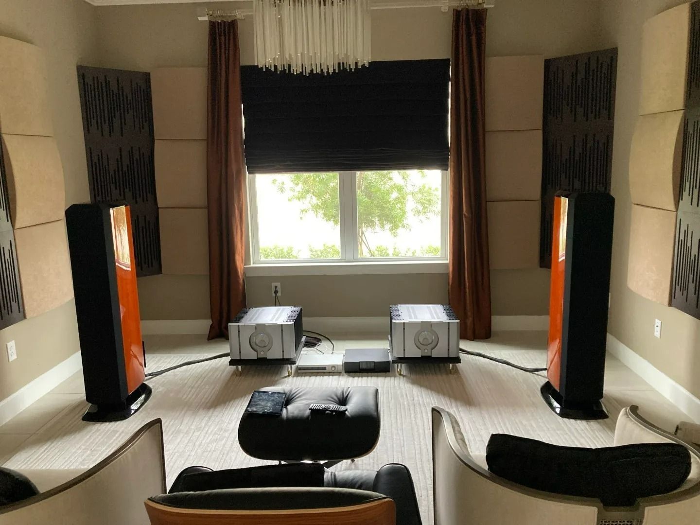 A living room with a lot of speakers and a window
