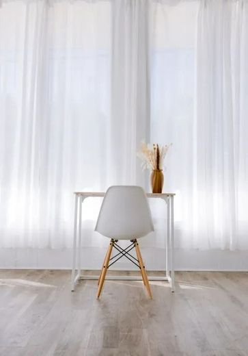A chair is sitting at a desk in front of a window.