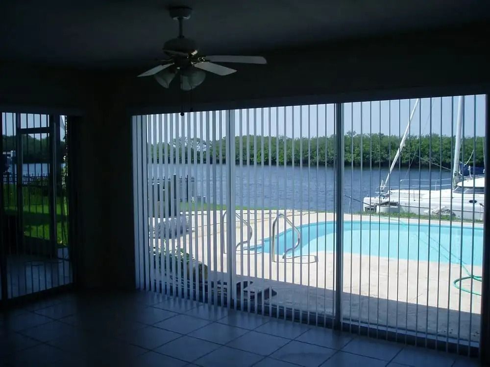 A room with sliding glass doors looking out to a pool