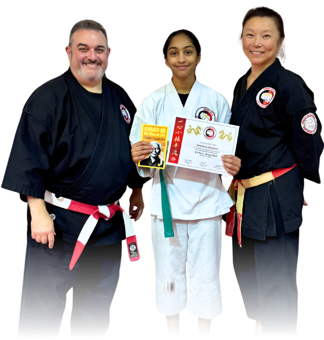Man pointing, smiling, wearing black hoodie; arm tattoo visible.