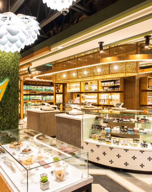 Interior of a cannabis dispensary, showcasing products in glass display cases, modern lighting, and wood accents.
